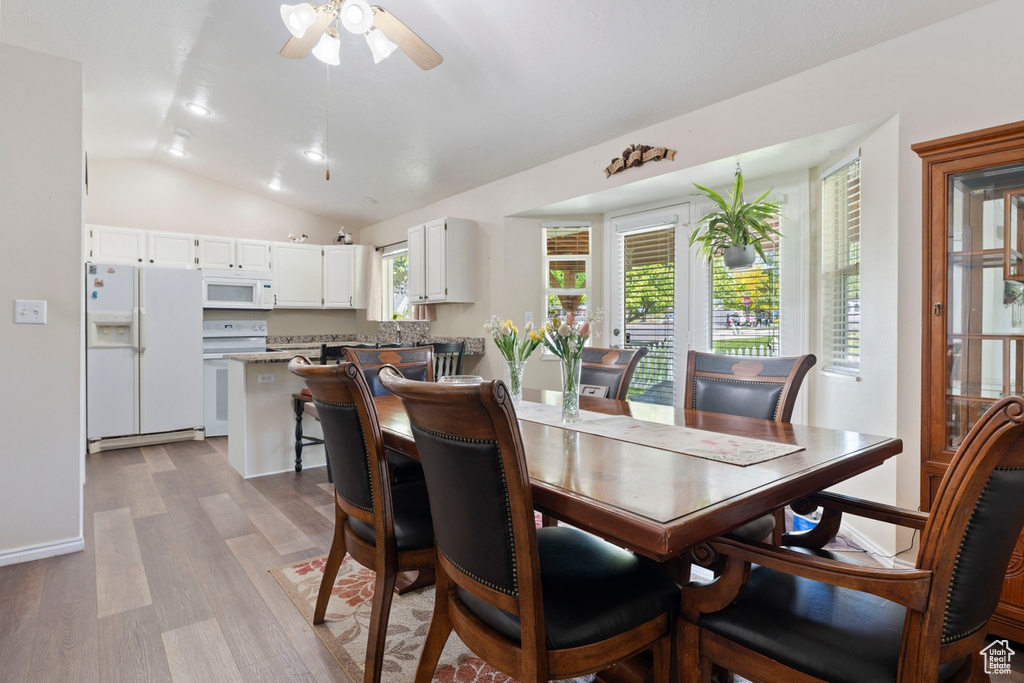 Dining space featuring vaulted ceiling, ceiling fan, and wood finished floors