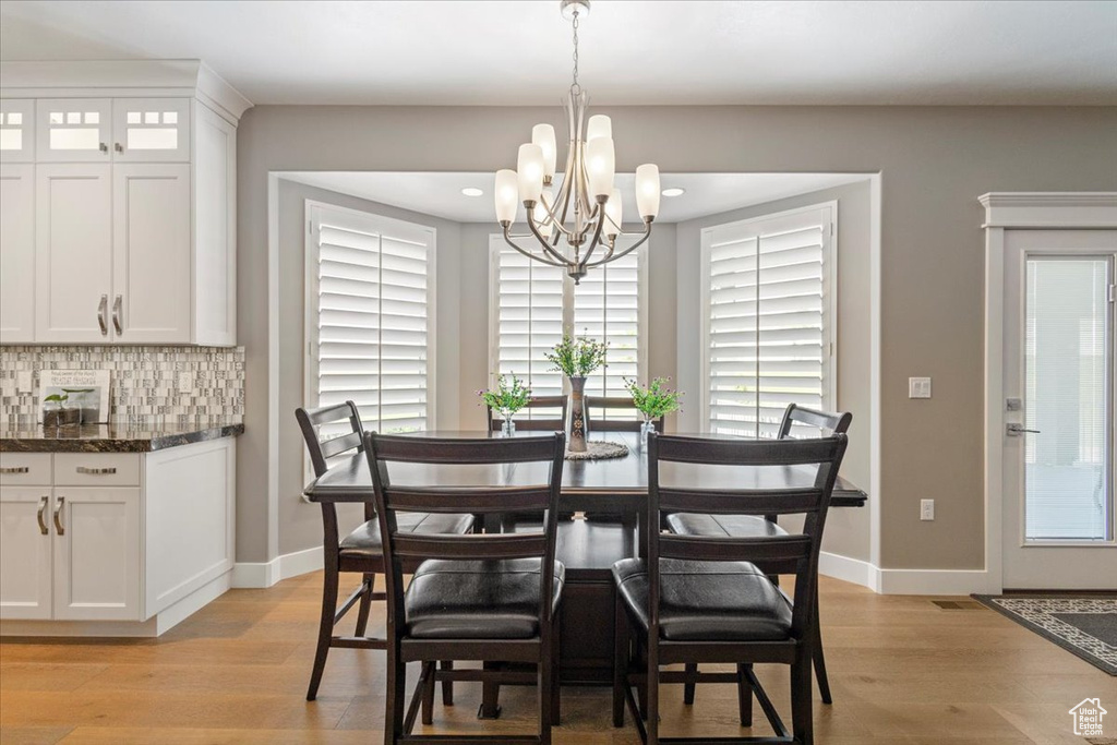 Dining area featuring a chandelier, light wood-type flooring, baseboards, and recessed lighting