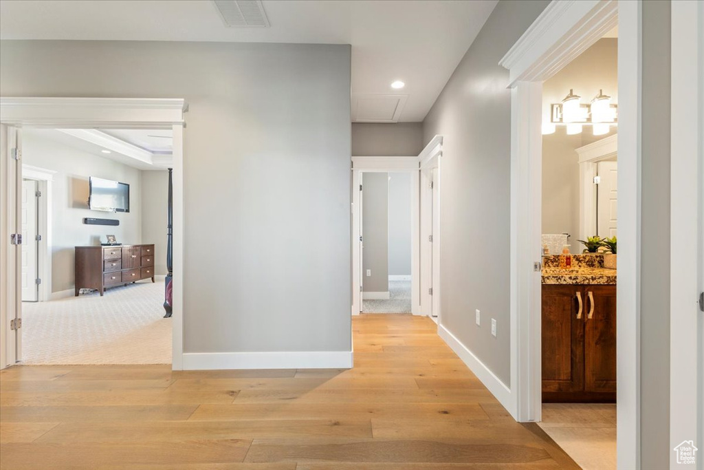 Hallway with light wood-style floors, attic access, baseboards, and recessed lighting