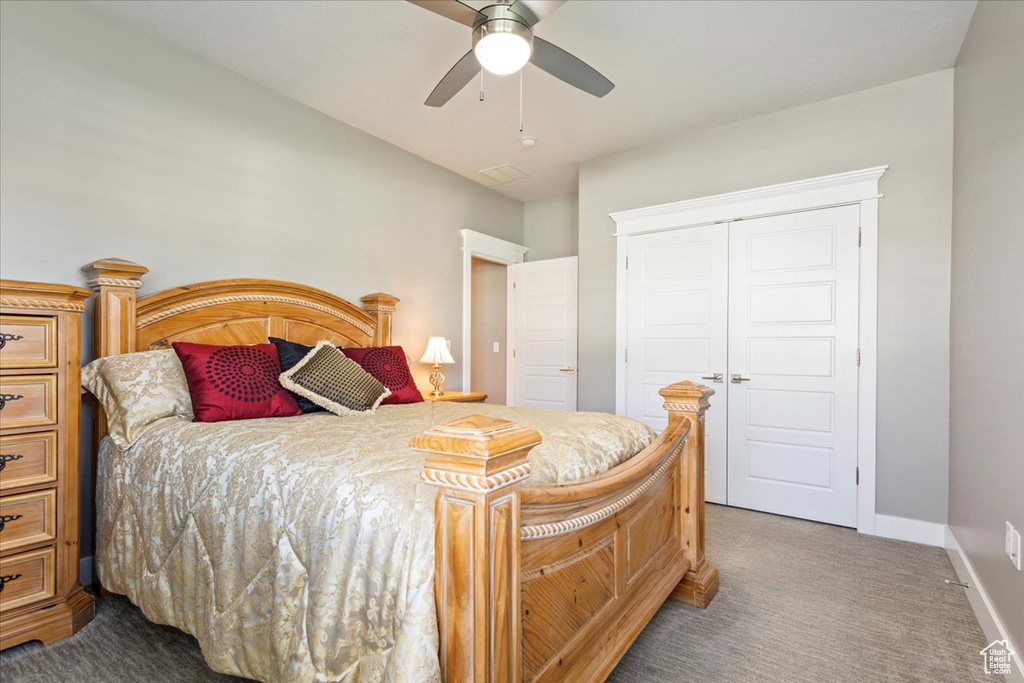 Carpeted bedroom with a closet, baseboards, and ceiling fan