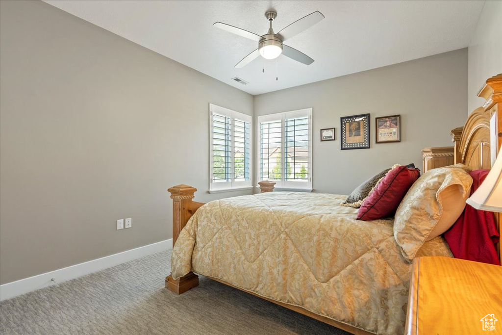 Carpeted bedroom with baseboards and a ceiling fan