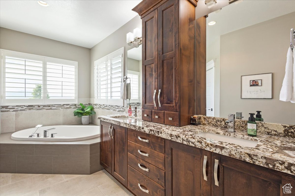 Bathroom with double vanity, a bath, and tile patterned floors