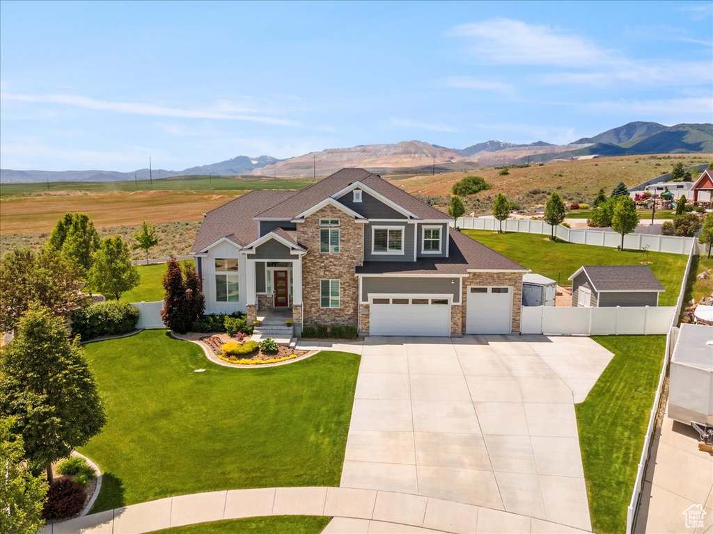 Craftsman-style house with a mountain view, driveway, stone siding, and an attached garage