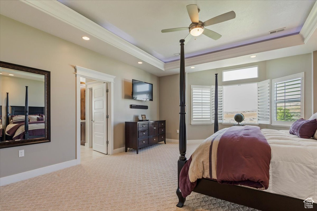 Bedroom featuring light carpet, a tray ceiling, recessed lighting, baseboards, and ceiling fan