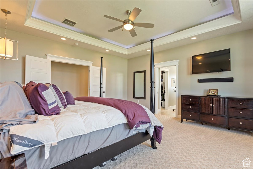 Bedroom featuring a tray ceiling, light carpet, recessed lighting, baseboards, and crown molding