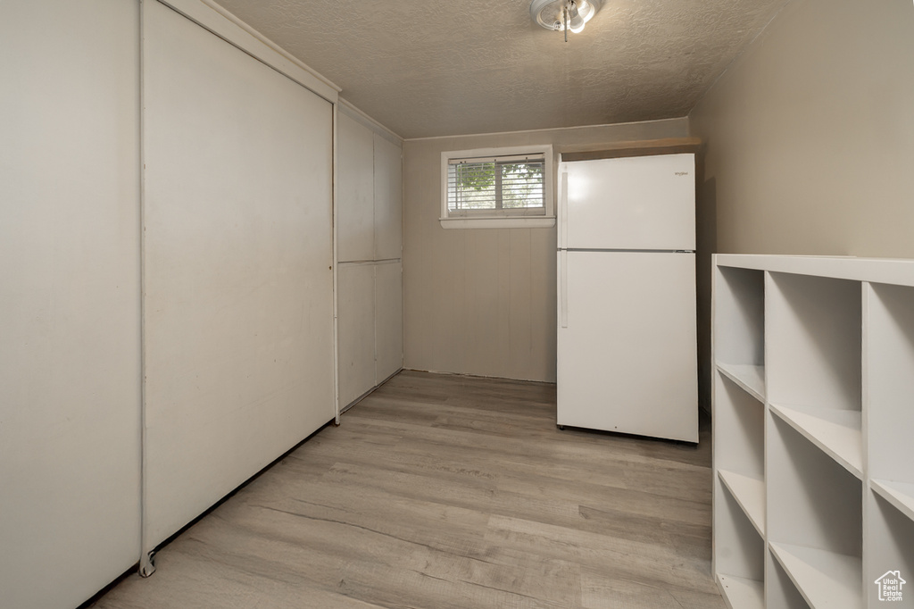 Interior space with a textured ceiling and light wood finished floors