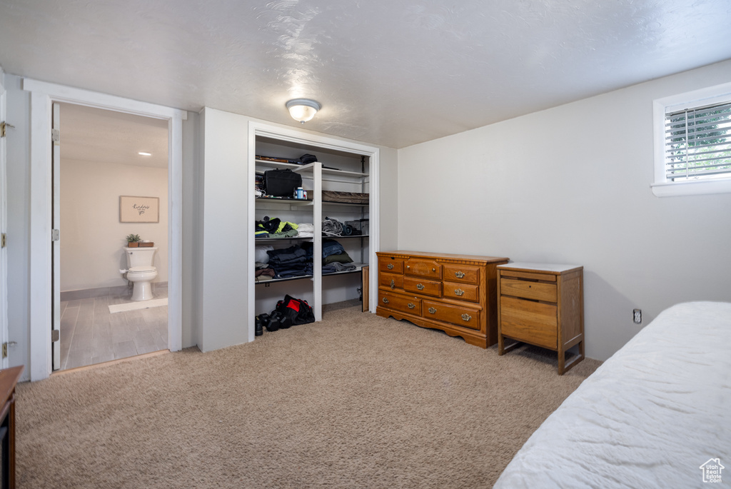Bedroom with carpet floors, a closet, and ensuite bath