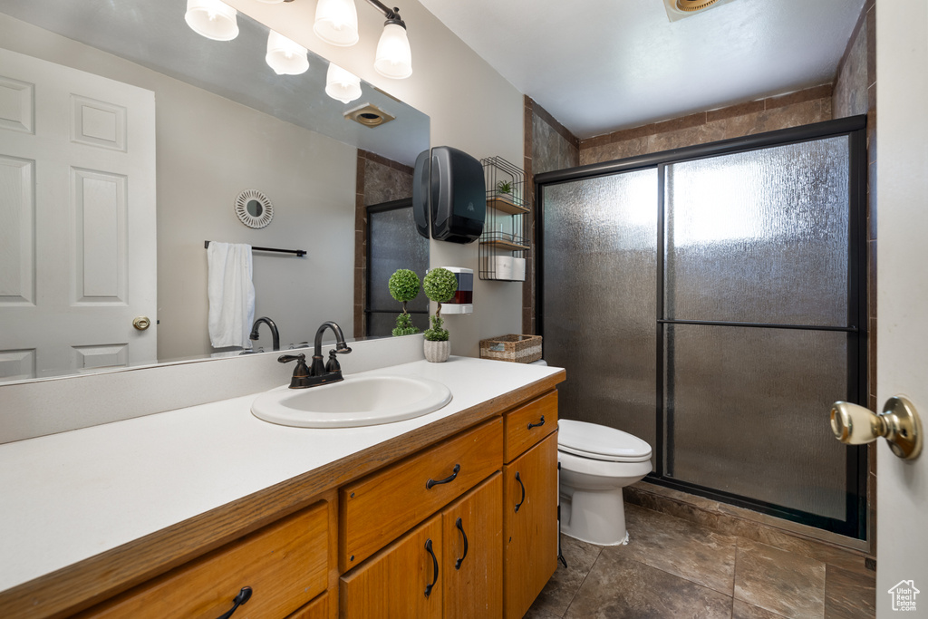Bathroom with vanity, a stall shower, and toilet