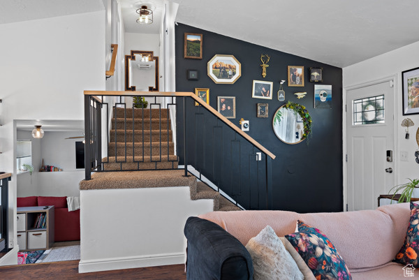Stairs with wood finished floors and lofted ceiling