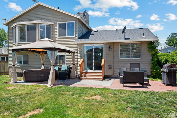 Rear view of house featuring outdoor lounge area, a gazebo, a patio, entry steps, and a chimney