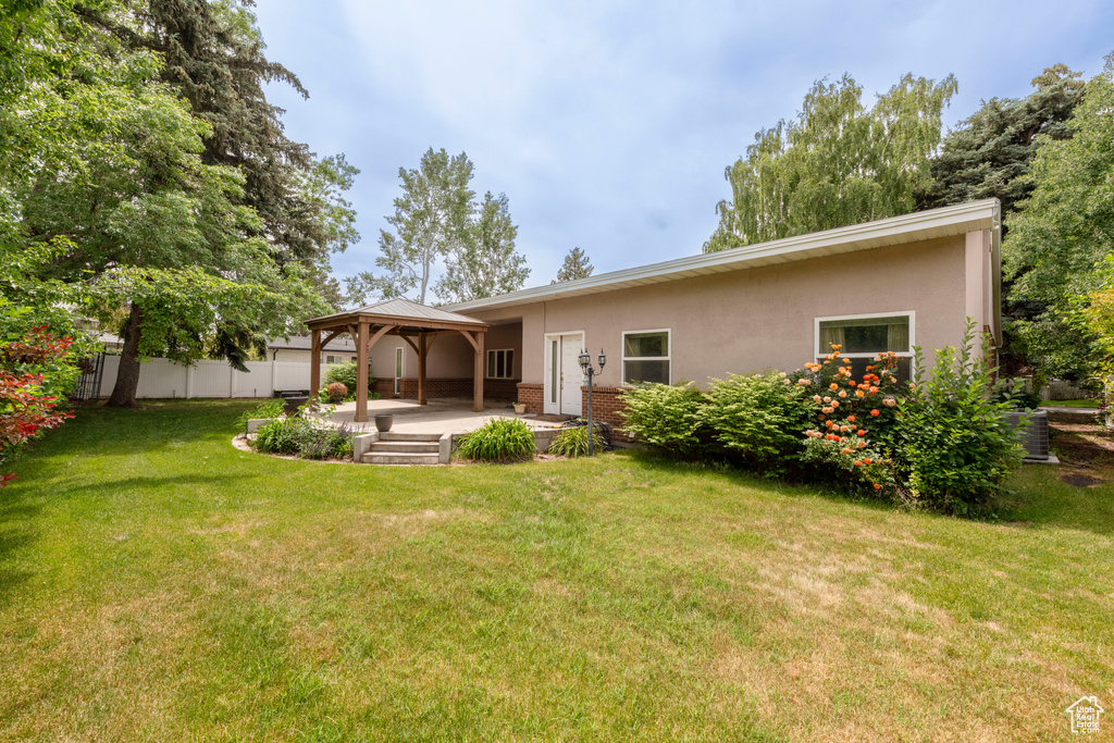 Back of house featuring a gazebo, stucco siding, and a patio area
