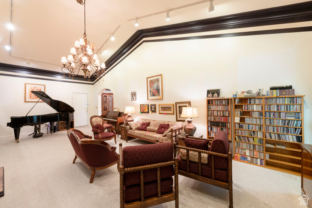 Sitting room with track lighting, arched walkways, lofted ceiling, carpet, and a chandelier