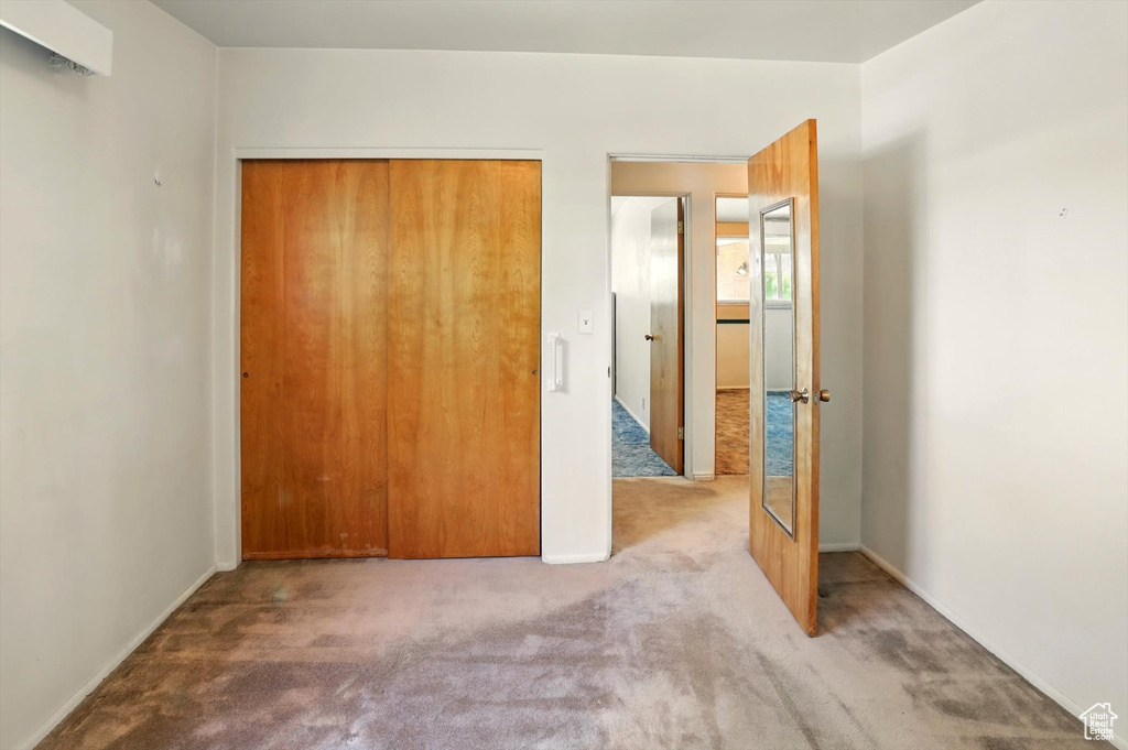 Unfurnished bedroom with carpet floors, a closet, and baseboards