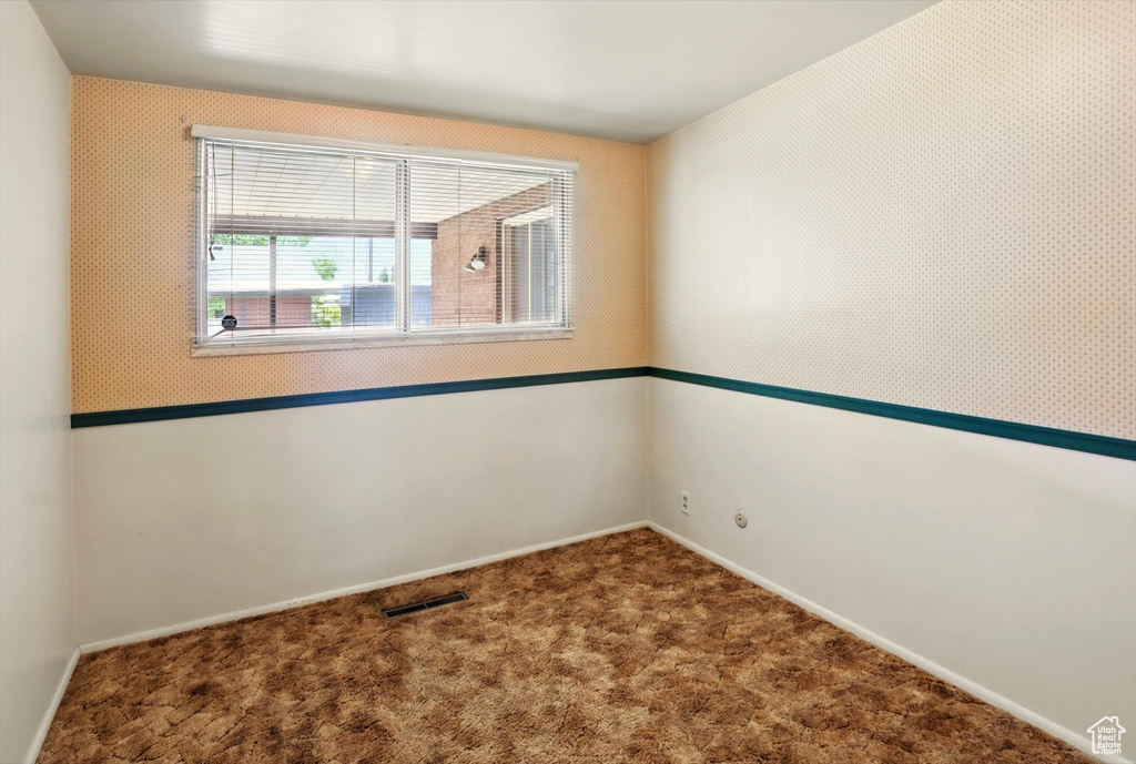 Spare room featuring baseboards and carpet flooring