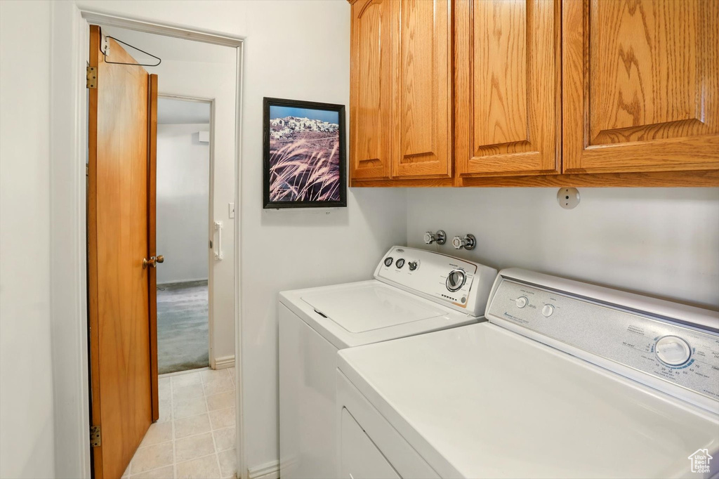 Washroom with washing machine and clothes dryer and cabinet space