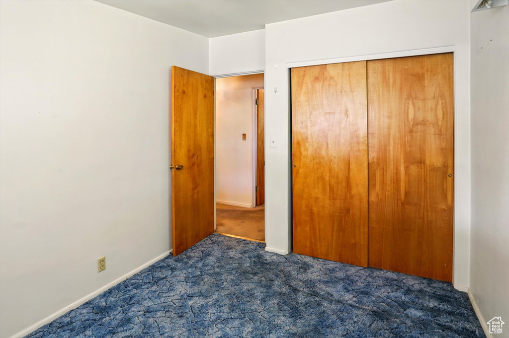 Unfurnished bedroom featuring carpet flooring, a closet, and baseboards