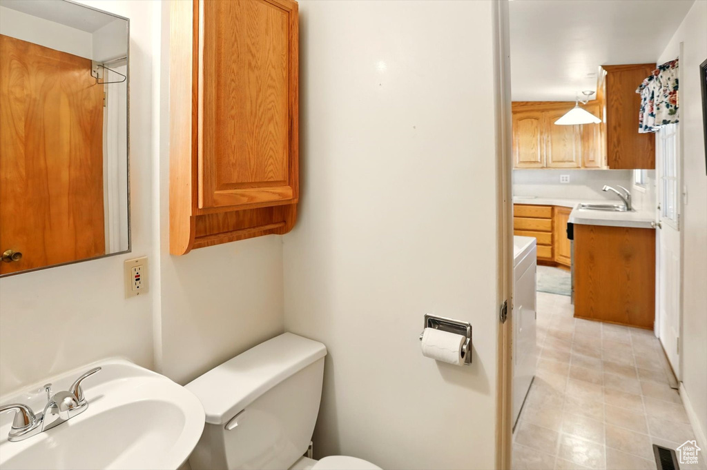 Bathroom featuring a sink, toilet, and tile patterned flooring