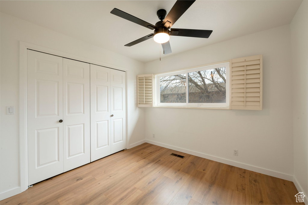 Unfurnished bedroom with baseboards, light wood-style floors, a closet, and ceiling fan