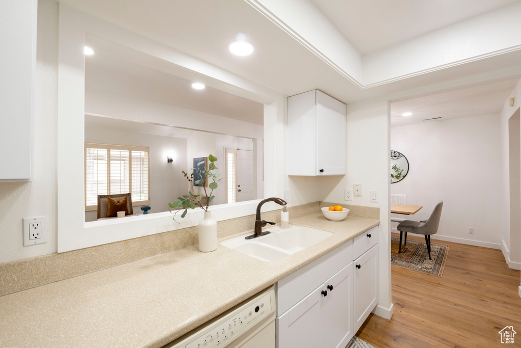 Kitchen featuring a sink, recessed lighting, white cabinetry, light wood finished floors, and light countertops