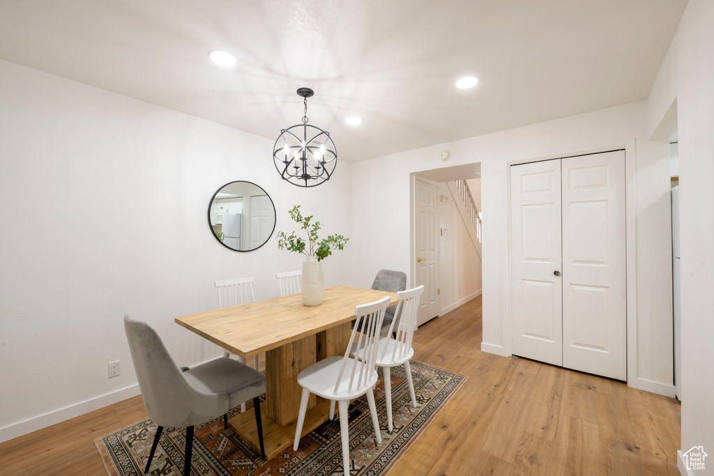 Dining area featuring a chandelier, baseboards, light wood finished floors, and recessed lighting
