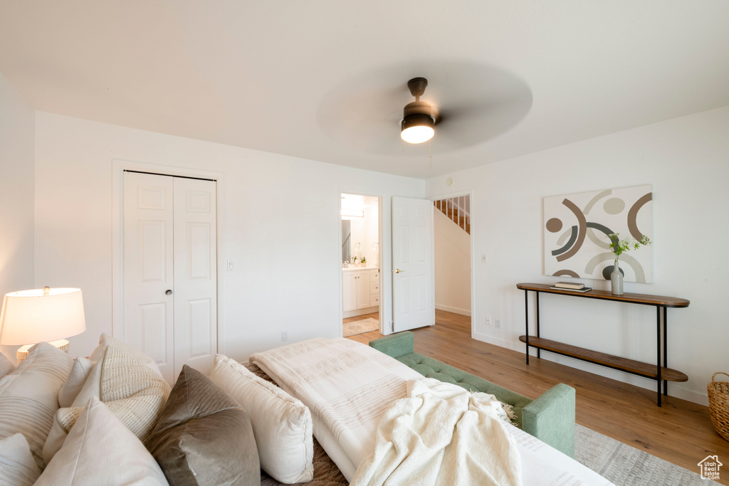 Bedroom with light wood-style floors, a closet, baseboards, connected bathroom, and ceiling fan