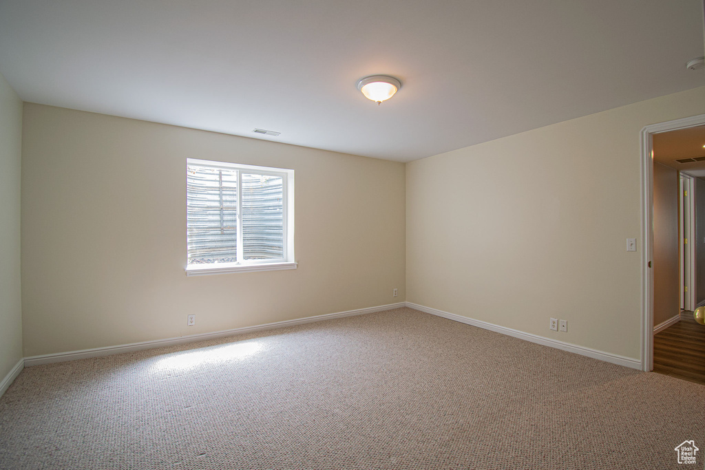 Carpeted spare room with baseboards