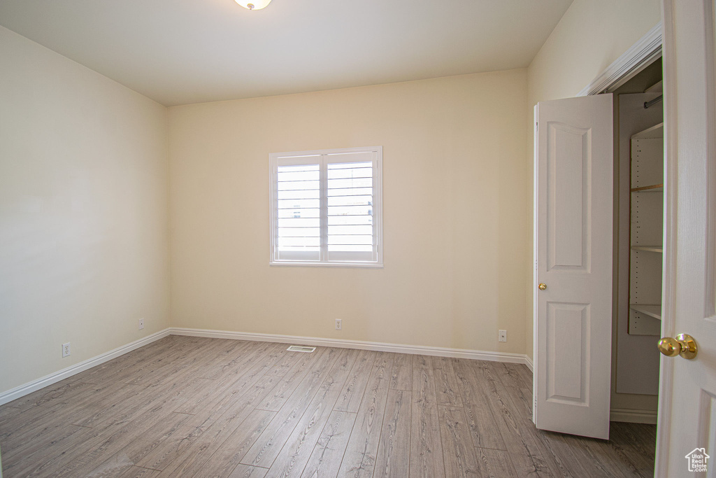Unfurnished room with wood finished floors and baseboards