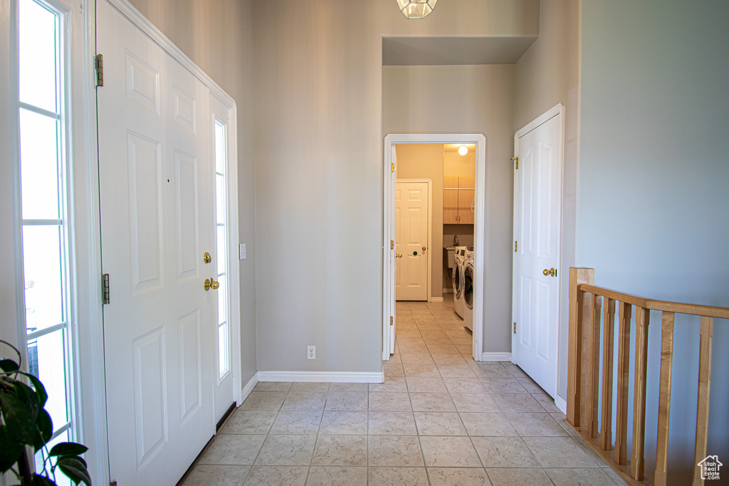 Entryway with separate washer and dryer and baseboards