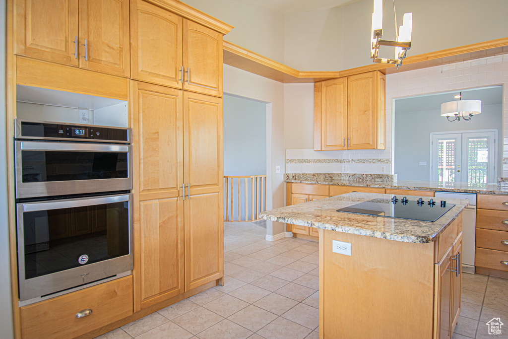 Kitchen with stainless steel double oven, black electric cooktop, light brown cabinetry, and light tile patterned floors
