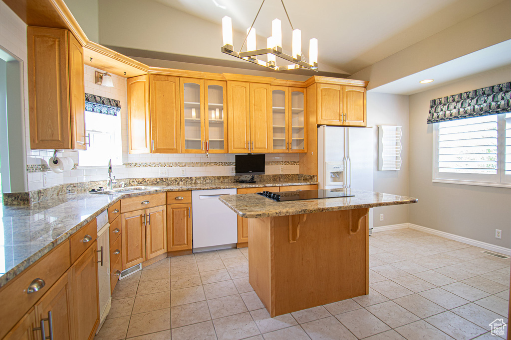 Kitchen with dishwasher, a sink, healthy amount of natural light, black electric cooktop, and vaulted ceiling