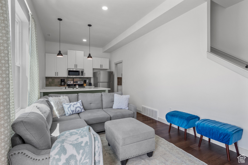 Living area with dark wood-style flooring, baseboards, and recessed lighting