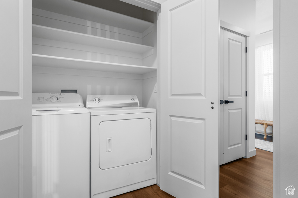Washroom featuring washing machine and dryer and dark wood finished floors
