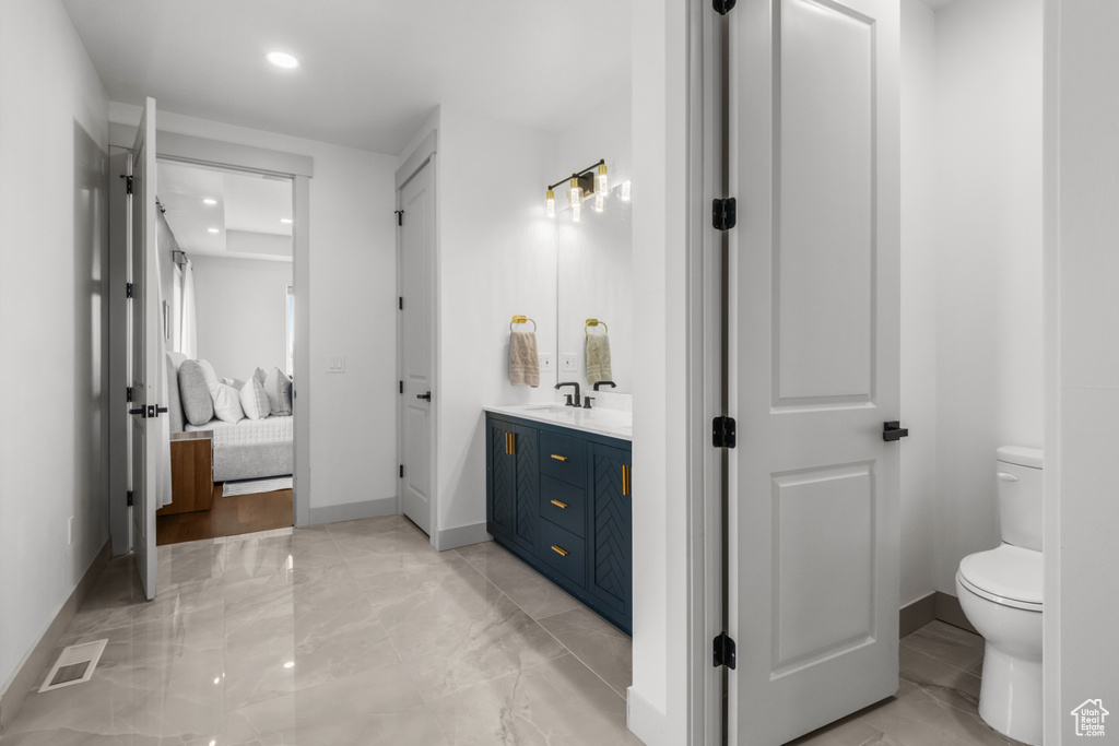 Bathroom with ensuite bath, double vanity, baseboards, toilet, and recessed lighting