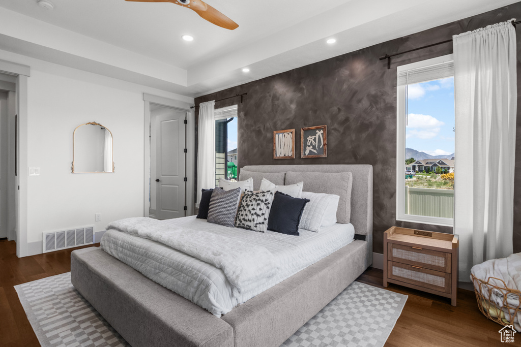 Bedroom with wood finished floors, recessed lighting, multiple windows, and a ceiling fan