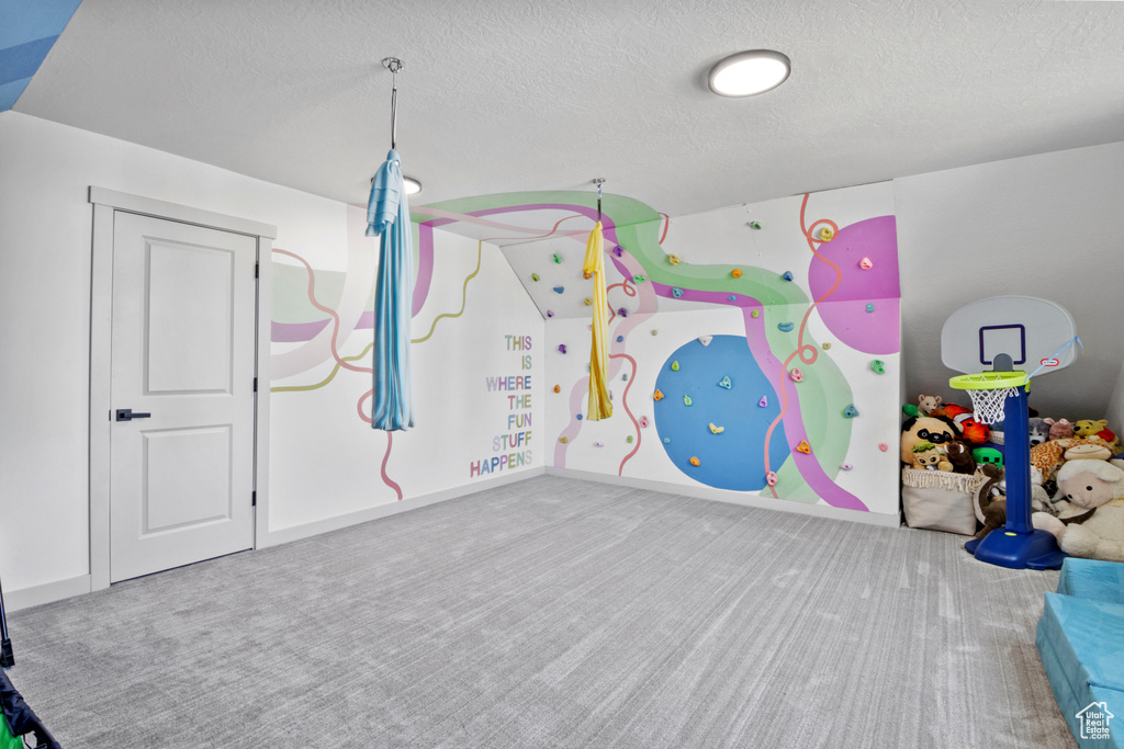 Playroom with carpet and a textured ceiling