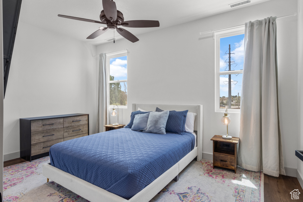 Bedroom featuring wood finished floors, baseboards, and ceiling fan