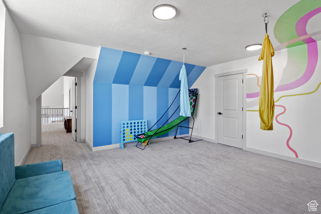 Rec room featuring carpet flooring, a textured ceiling, and baseboards