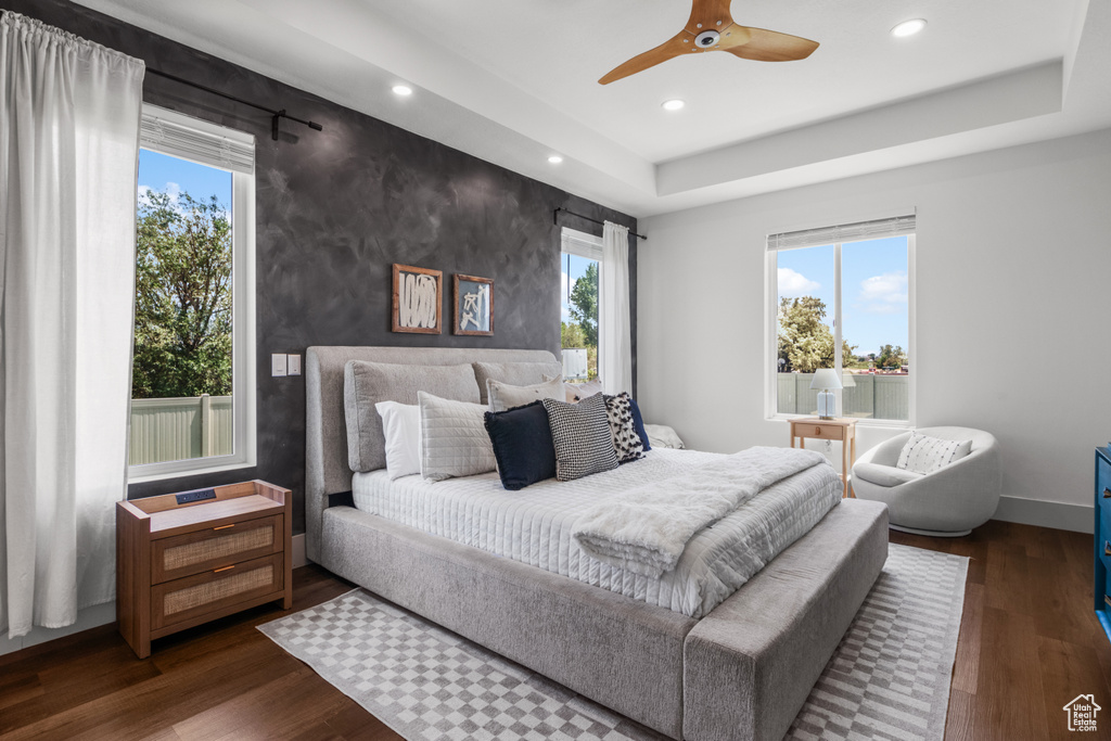 Bedroom featuring recessed lighting, multiple windows, dark wood-style flooring, baseboards, and an accent wall