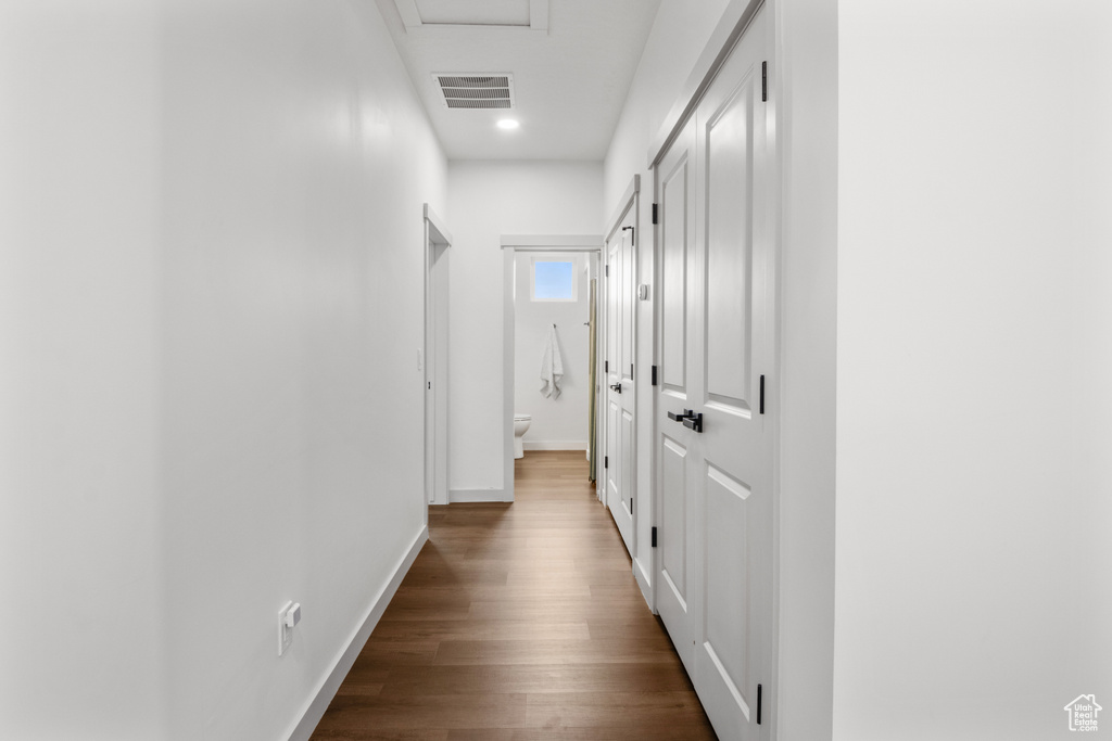 Hall with dark wood-type flooring, baseboards, and recessed lighting
