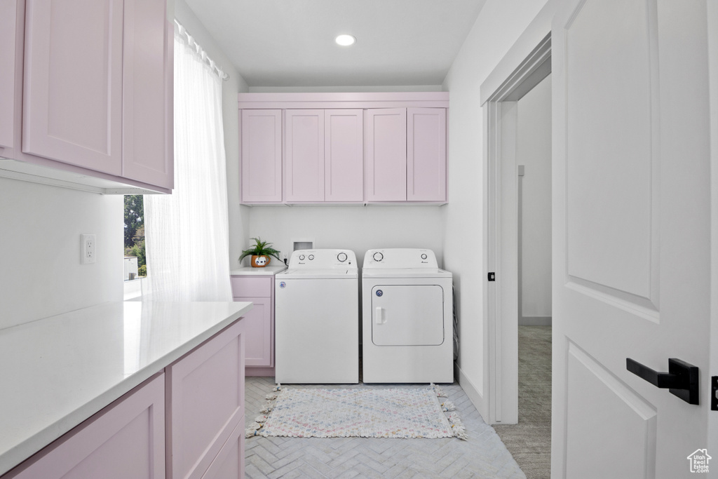 Washroom with cabinet space, washing machine and clothes dryer, healthy amount of natural light, and recessed lighting