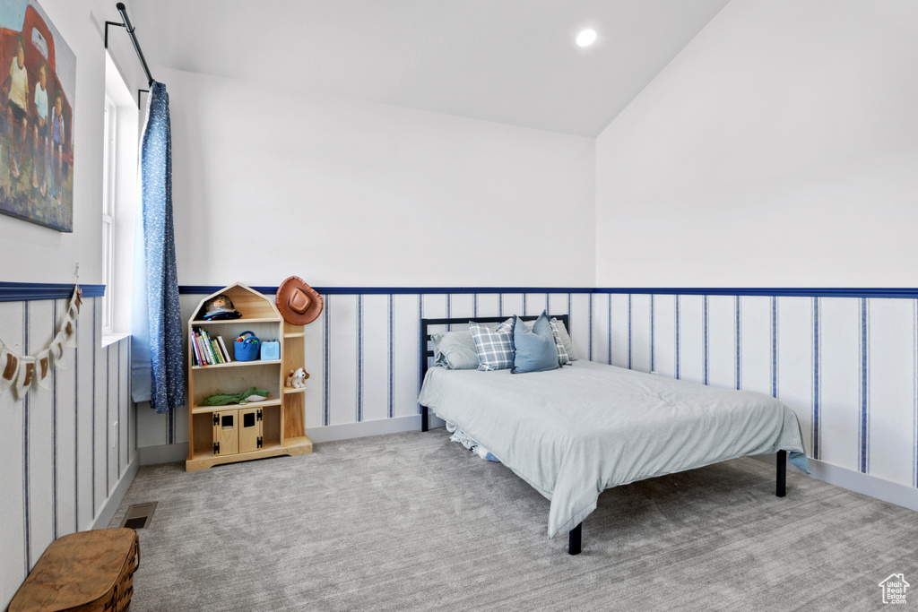 Carpeted bedroom with lofted ceiling, a wainscoted wall, and recessed lighting