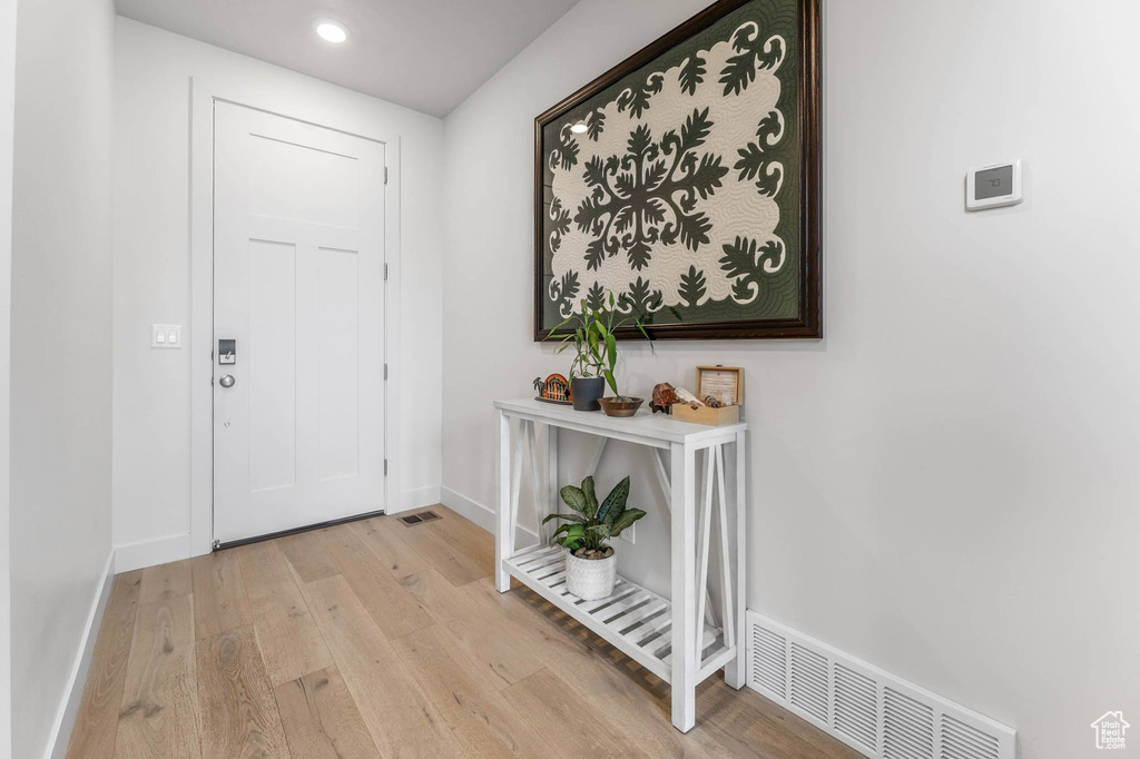 Foyer entrance with wood finished floors, baseboards, and recessed lighting