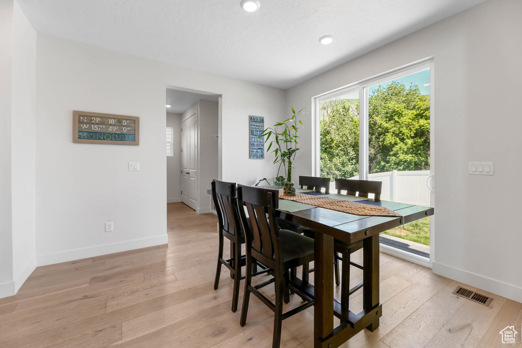Dining space featuring baseboards, light wood-type flooring, and recessed lighting