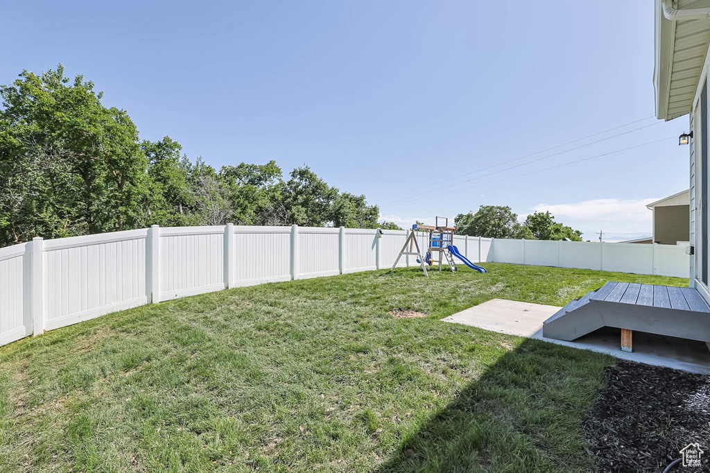 View of yard with a playground and a patio