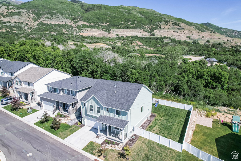 Aerial view of property and surrounding area featuring a mountain backdrop