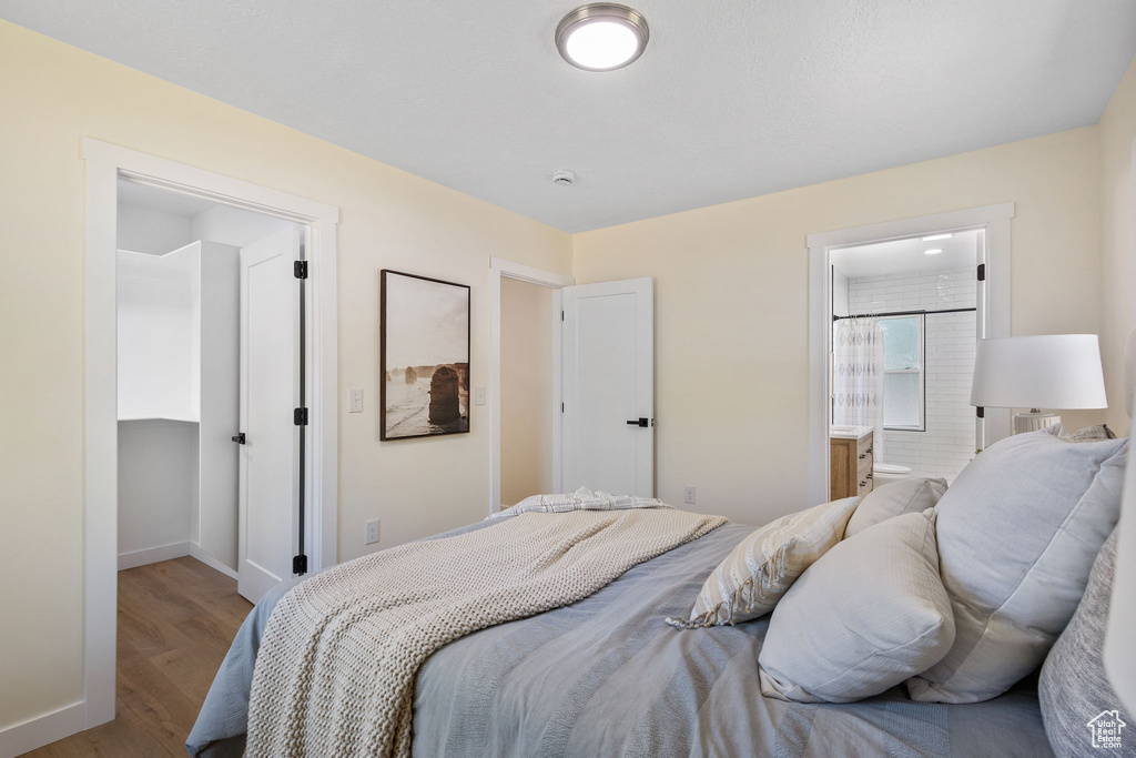 Bedroom with wood finished floors and ensuite bath
