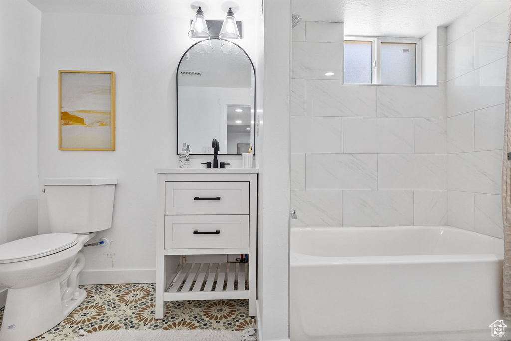 Full bath featuring tile patterned flooring, vanity, and bathtub / shower combination