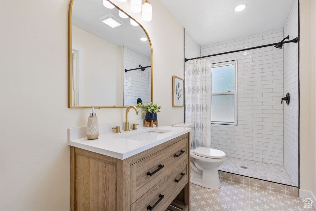 Bathroom featuring vanity, a tile shower, and recessed lighting