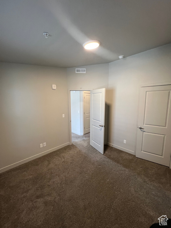 Unfurnished room with carpet flooring, baseboards, and a pendent fire sprinkler