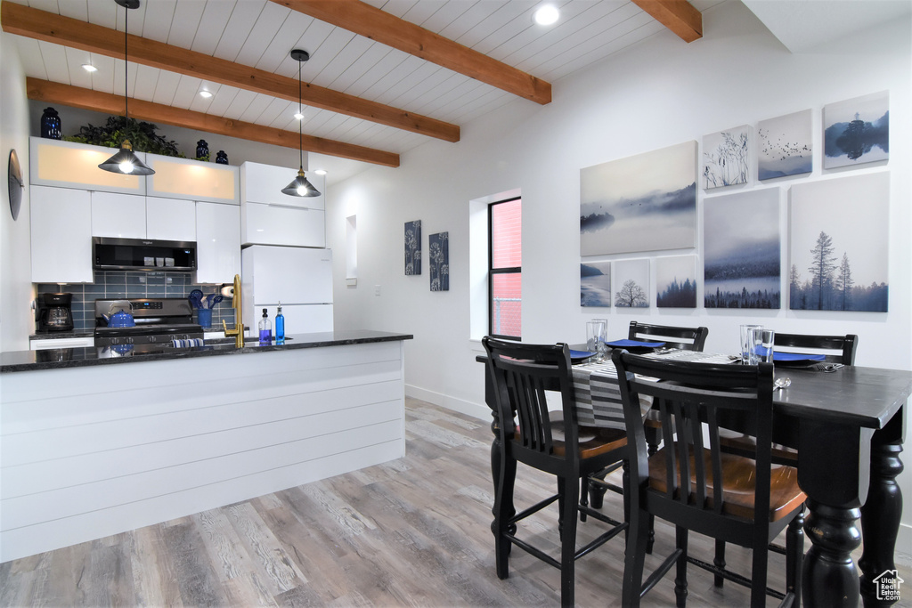 Dining area featuring recessed lighting, light wood-style flooring, baseboards, and wood ceiling with exposed beams